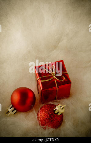 Vertikale Schuss rot Weihnachtsdekorationen im unteren Teil des Rahmens liegen in langhaariger Kunstpelz.  Im Alter von Vintage-Effekt. Stockfoto