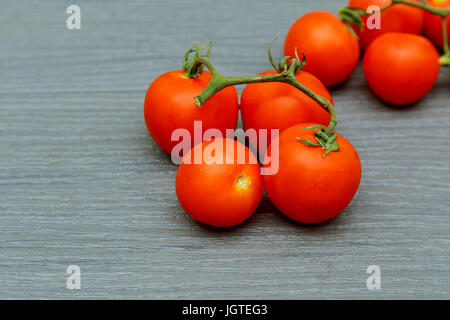 Tomaten. Cherry-Tomaten. Cocktailtomaten. Frische Trauben Tomaten Karaffe mit Olivenöl auf Tisch. Stockfoto