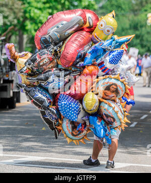 ein Mann verkauft Helium gefüllt Ballons unterschiedlicher Designs bei einer Parade von Southampton in Southampton, New York Stockfoto