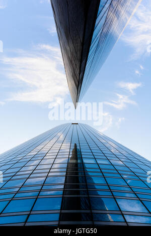 Niedrigen Winkel auf Wolkenkratzer und Glasbauten mit blauem Himmel in einer geometrischen Anordnung. Stockfoto
