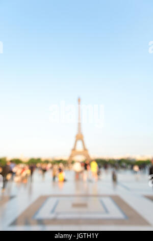 Unscharfer Blick auf den Eiffelturm in Paris, Frankreich, von der Esplanade Trocadero in ein warmes Licht bei Sonnenuntergang gesehen. Stockfoto