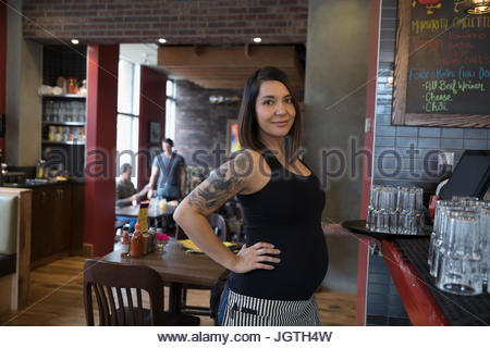 Porträt sicher schwanger, tätowierte Kellnerin im restaurant
