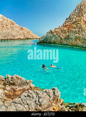 vertikale Panorama-Bild der kaukasischen Pärchen schwimmen in klaren türkisblauen Wasser des Mittelmeeres an Seitan Limania umgeben von Felsen Stockfoto