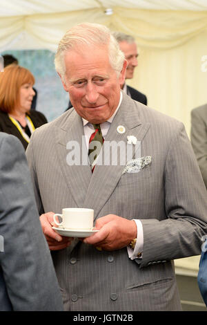 Der Prinz von Wales hat eine Tasse Tee, da er mit Gesellschafter plaudert nach der offiziell Eröffnung Volac International neue Biomasse-Anlage in Ciliau Aeron, die nachhaltige Holz-Brennstoff verwendet, um Energie zu produzieren, vor der Teilnahme an einem Empfang mit Mitarbeitern und Stakeholdern in Dyffryn Aeron Tal, Felinfach. Stockfoto