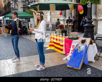 Ein junger Mann und Frau verkaufen rote Rosen auf Sant Jordi Tag, Barcelona, Spanien. Stockfoto