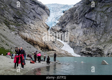 Touristen besuchen Briksdalsbreen oder Briksdal Gletscher Arm des Jostedalsbreen, über Briksdalsbrevatnet See im Nationalpark Jostedalsbreen, Norwegen Stockfoto