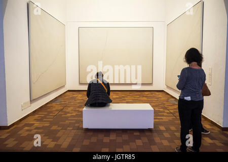 Zwei Frauen vor Joan Miro, Malerei auf weißem Hintergrund für die Zelle eines Einsiedlers, in der Fundacio Joan Miro, Montjuic, Barcelona Spanien. Stockfoto