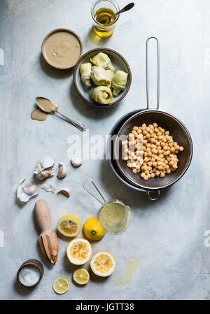 Zutaten für Hummus, einschließlich Kichererbsen, Knoblauch, Zitrone und Artischocken Stockfoto