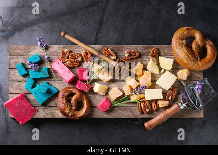 Auswahl an bunten Holland Käse traditionell weich, alt, rosa Basilikum, blauen Lavendel serviert mit Pecan-Nüssen, Honig, Lavendelblüten, Brezeln Brot auf Stockfoto