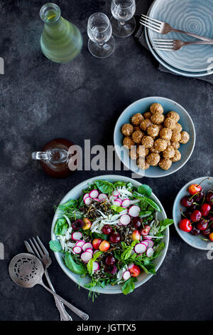 Kirsche Wildreis-Salat mit Hibiskus-Vinaigrette serviert mit Weißwein.  Auf schwarz/grau Hintergrund fotografiert. Stockfoto