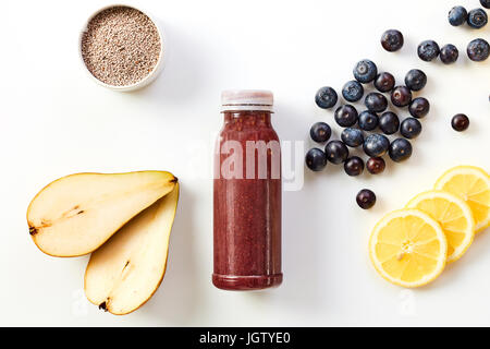 Gesunde Smoothie Getränke mit frischem Obst wie Birne, Heidelbeeren, Zitrone und Chia Samen angeordnet, um eine Flasche gemischte Saft auf einem weißen Hinterg Stockfoto