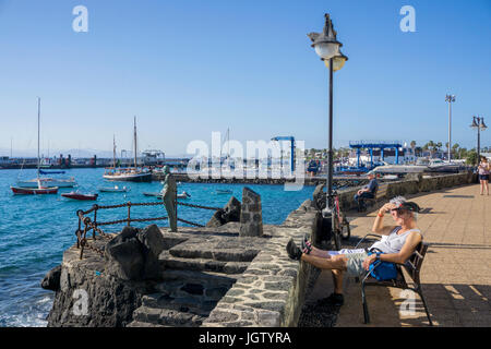 Alte Paar auf der Werkbank auf Bronze Statue zu Ehren der Alten Kanarischen Generation (Artist Chano Navarro Betancor), Playa Blanca, Lanzarote Kanarische Inseln Stockfoto