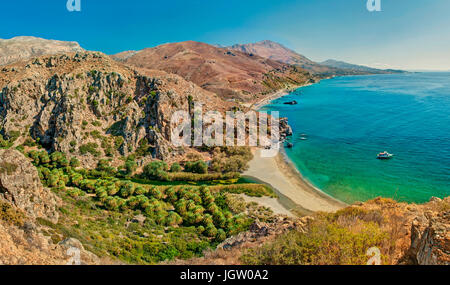 Panoramablick auf Palm-Baum-Wald und Strand von Preveli, umgeben von Bergen an sonnigen Sommertag, Kreta, Griechenland Stockfoto