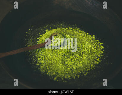 Japanische Matcha-Grüntee-Pulver in Holzschale mit Löffel Stockfoto