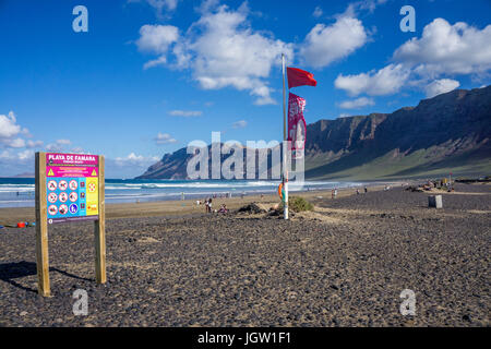 Red Flag (Schwimmen) am Famara Strand entfernt, hinter dem Famara-gebirge, La Caleta de Famara, Lanzarote, Kanarische Inseln, Spanien, Europa Stockfoto