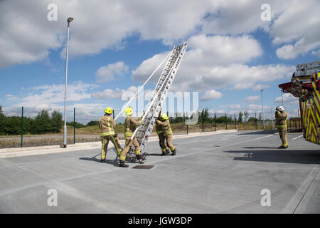 UK-Feuerwehrleute üben mit Leitern Stockfoto