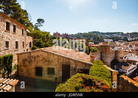 Blick auf die Stadt von den Mauern der Festung in Tossa de Mar. Klar Sommertag in Spanien. Die Altstadt und die Häuser aus Stein unter der heißen Sonne. Stockfoto