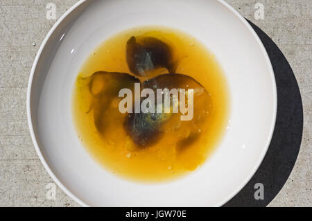 faules Ei in eine Schüssel mit laufende schwarze Streifen weiß Stockfoto