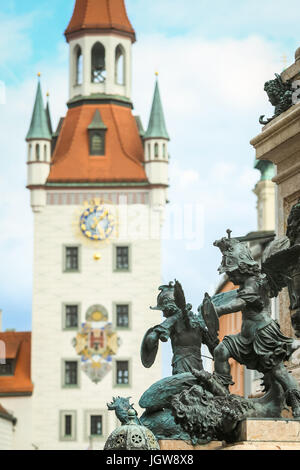 München, Deutschland - 9. Mai 2017: Das Podest der Jungfrau Maria Statue mit putto Statue und das Alte Rathaus am Marienplatz in München. Stockfoto