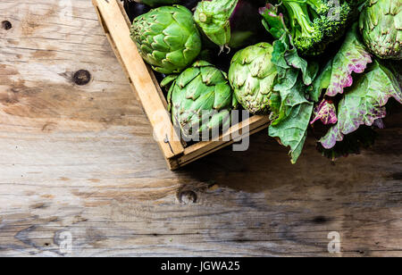 Kochen Hintergrund Ernte Konzept. Frische organische grünes Gemüse in Holzkiste Stockfoto