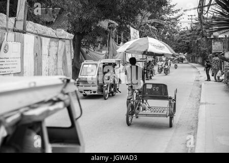 Schwarz / weiß Bild von Tuk Tuk, Motorräder und ein Mann Reiten Fahrrad Stockfoto