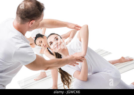 Trainer mit Mädchen üben Variation der drehte sich Seite Winkel darstellen (Parivrtta Parsvakonasana) Stockfoto