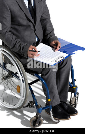 Schuss von körperlich behinderten Geschäftsmann im Rollstuhl Vertragsunterzeichnung beschnitten Stockfoto