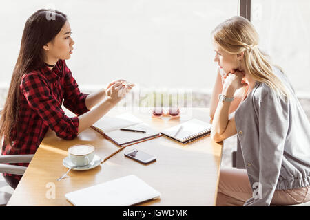 Seitenansicht des jungen Frauen reden während Geschäftstreffen Mittagessen im café Stockfoto