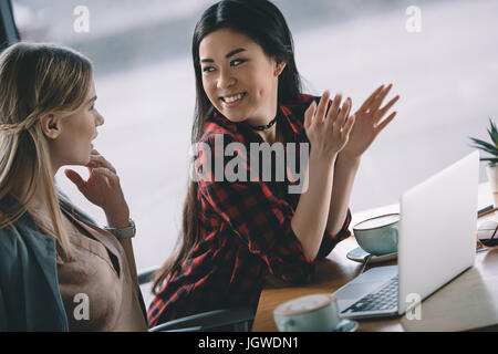 junge attraktive Frauen auf Kaffeepause mit Laptop im café Stockfoto