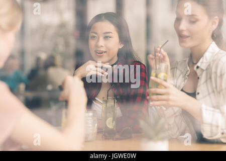 junge Mädchen tranken Cocktails zusammen sitzend am Tisch im Café, beim Mittagessen Stockfoto