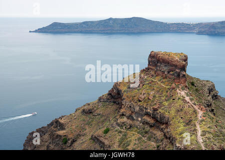Sakros Rock mit vulkanischen Insel Nea Kameni im Hintergrund, Santorini, Griechenland Stockfoto