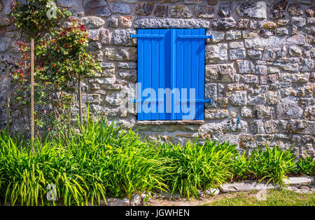 Geschlossenen blauen Fenstervorhänge im Steinhaus Stockfoto