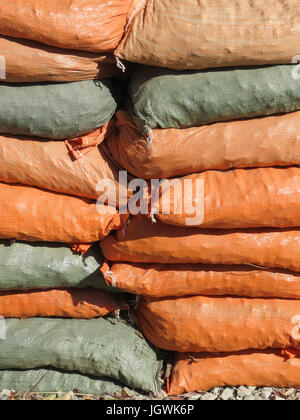 Nahaufnahme der Stapel von orange und grau Sandsäcke, die verwendet wurden, um Erosion während der Regenzeit in Südkalifornien zu stoppen;  Schatten, Muster. Stockfoto