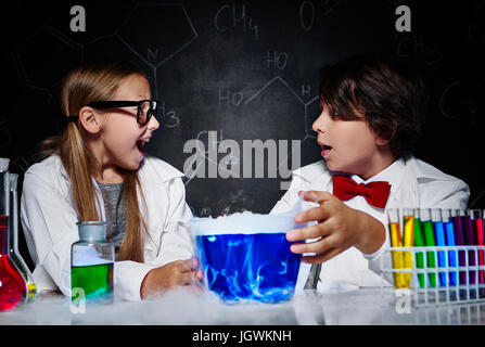Glückliche kleine Wissenschaftler an den Chemieunterricht Stockfoto