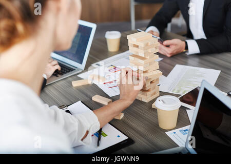 Team von Geschäftsleuten bauen eine Holzkonstruktion. Konzept der Teamarbeit und Partnerschaft Stockfoto