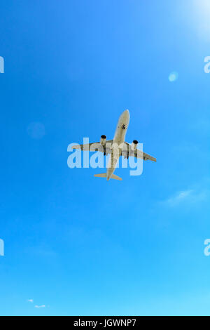 Blick von unten auf ein fliegendes Verkehrsflugzeug im Ansatz der Landung oder ausziehen. Stockfoto