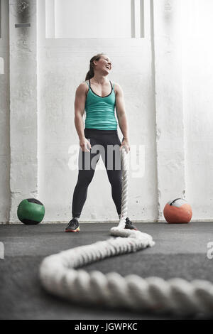 Frau mit Schlacht Seil in cross-Training-Fitness-Studio Stockfoto