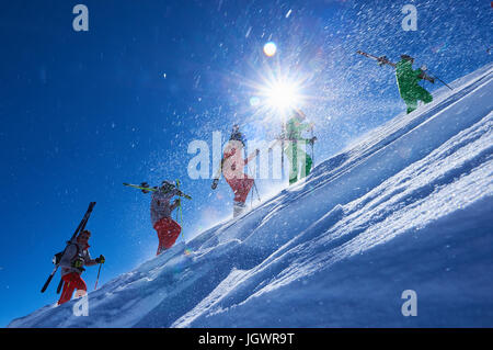 Fünf männliche Skifahrer stapfen auf steilen sonnigen Berghang, Aspen, Colorado, USA Stockfoto