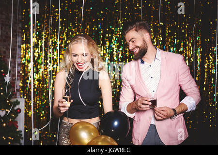 Mann und Frau auf Party, hält Getränke, lachen Stockfoto