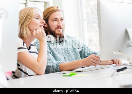 Männliche und weibliche Designer Blick auf Desktop-Computer im Kreativstudio Stockfoto