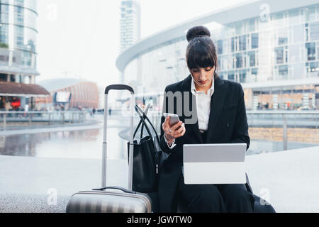 Geschäftsfrau mit Trolley-Gepäck mit Handy und digital-Tablette, Mailand, Italien Stockfoto