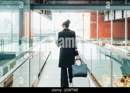 Geschäftsfrau mit mobilen und ziehende Trolley Gepäck, Mailand, Italien Stockfoto