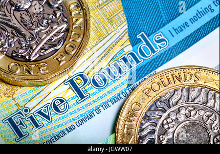 Britische £1 und £2 Münzen auf eine Anmerkung £5 Stockfoto