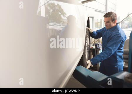 Echter Profi. Zuständigen aufmerksam fleißig Spezialist dafür autos Teilen arbeiten direkt nach der Installation eines neuen Satzes Reifen Stockfoto