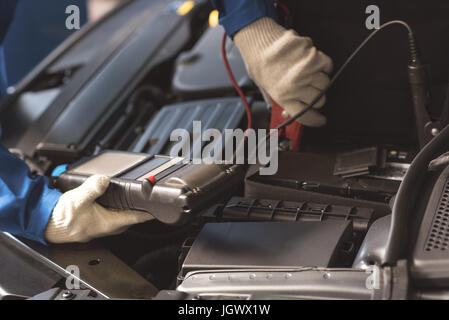 Kabel einstecken. Talentierte geschickte ausgebildete Soldaten mit speziellen Indikator zur Messung etwas während der Durchführung eines allgemeinen Auto-checkup Stockfoto