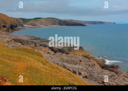 Ein entfernten Strand mit vielen Badegäste und Sonnenanbeter entspannen und spielen auf einem sandigen Strand an einem warmen Julitag mit der Flut heraus. Stockfoto