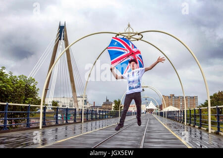 Southport, Merseyside, 11. Juli 2017. Großbritannien Wetter. Das schreckliche Wetter nicht dieses jungen Mannes Geister zu dämpfen, da er hoch oben der sonnigen Promenade auf Southport Pier in Merseyside springt. Ein östlicher Atlantik Wetter erzeugt Ausbrüche von persistent und teils heftigen Regen als Bewegung ostwärts in Nordwestengland. Bildnachweis: Cernan Elias/Alamy Live-Nachrichten Stockfoto