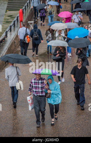 London, UK. 11. Juli 2017. Wimbledon-Brollly ist praktisch - stürmisches Wetter bringt Regen nach London und zieht Touristen aus in kurzen Hosen und T-shirts, während die wenigen glücklichen unter Sonnenschirmen als y Zuflucht die Millennium Brücke von St. Pauls Kathedrale. London 11. Juli 2017. Bildnachweis: Guy Bell/Alamy Live-Nachrichten Stockfoto