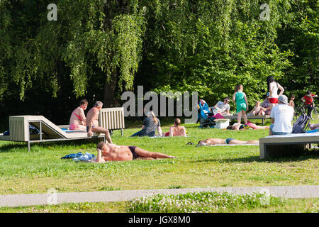 Russische Wetter, Moskau. Dienstag, 11. Juli 2017. Einen warmen und sonnigen Tag in Moskau nach der Folge des kalten und regnerischen Wochen. Die Temperatur über +24C (+ 75F). Können wir hoffen, setzt das Sommerwetter fair endlich? Die Leute gehen im Freien zu den Parks, in der Sonne, in der lokalen Teich schwimmen und nur ein Atem von Frischluft zu backen. Nicht identifizierte Personen haben etwas Sonne und etwas bräunen an einem kleinen Strand am lokalen Teich. Bildnachweis: Alex Bilder/Alamy Live-Nachrichten Stockfoto