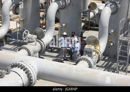 (170711)--BENI SUEF (Ägypten), 11. Juli 2017 (Xinhua)--chinesische Ingenieure aus China Petroleum Technologie & Development Corporation (CPRDC) kommunizieren mit ihren ägyptischen Kollegen am Beni Suef Bahnhof in Beni Suef, Ägypten, am 10. Juli 2017. Die Beni Suef Station, die erste Tankstelle für Regler betrieben durch China Petroleum Technologie & Development Corporation (CPRDC), eine Tochtergesellschaft der China National Petroleum Corporation (CNPC), startet Pumpen Erdgas im September, Li Qitang, sagte CPRDC Vertreter in Kairo Xinhua. CPRDC Vertrag einen 20-Millionen-Dollar-mit ägyptischen natürliche G Stockfoto